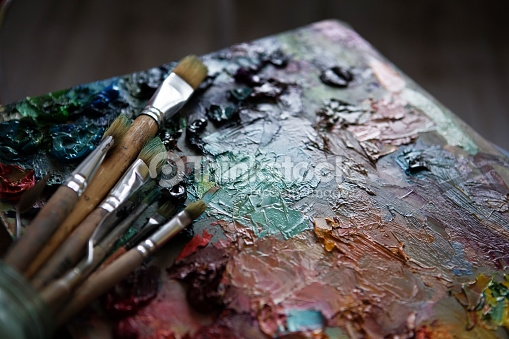 artists brushes and oil paints on wooden palette. macro artist's palette, texture mixed oil paints in different colors and saturation. palette with paintbrush and palette-knife